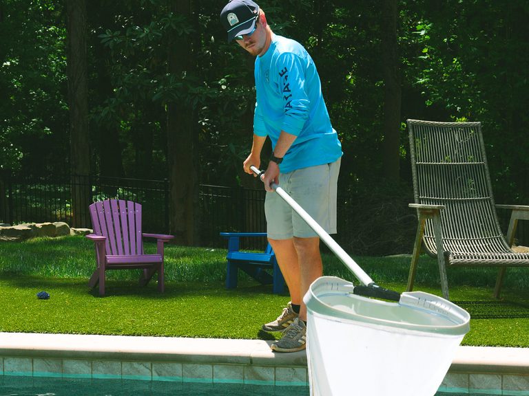 Pool technician performing weekly pool maintenance at a backyard pool in Atlanta GA