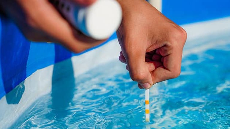 Pool technician testing water chemistry after a storm in Metro Atlanta