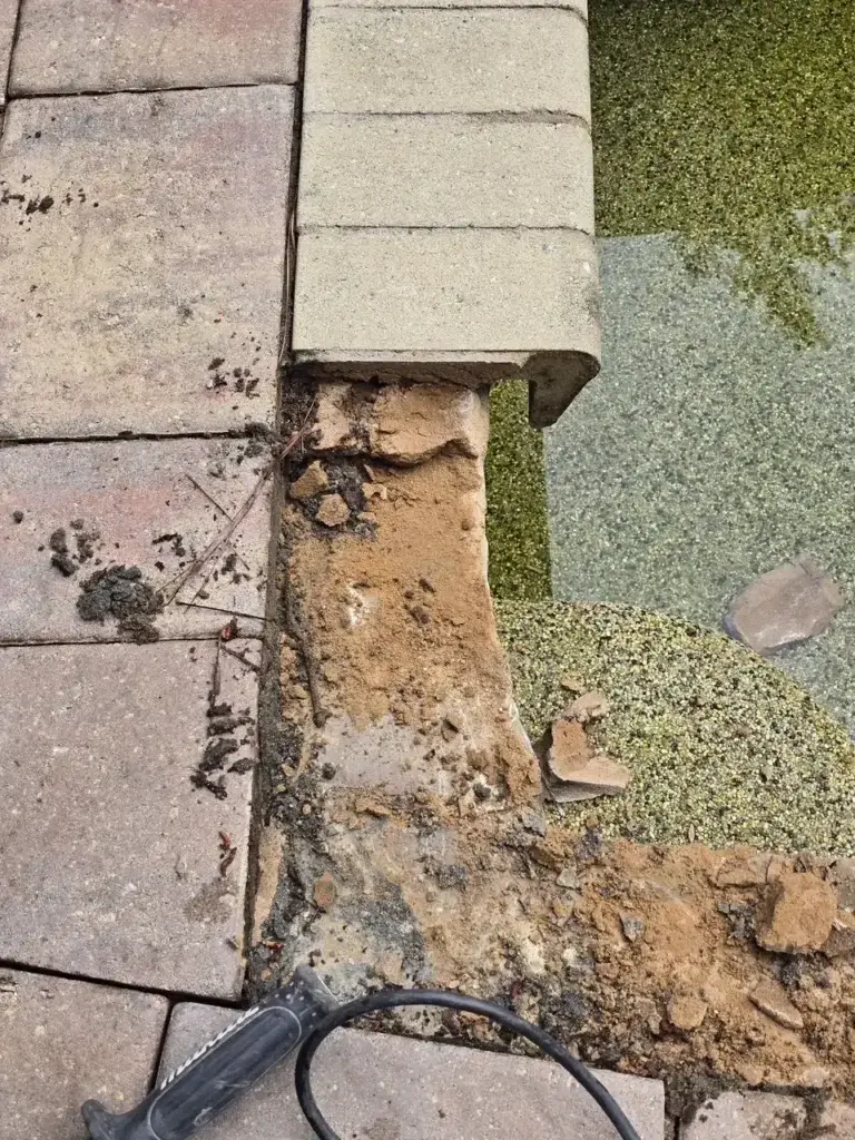 Deteriorated pool coping and crumbling structure underneath before repair