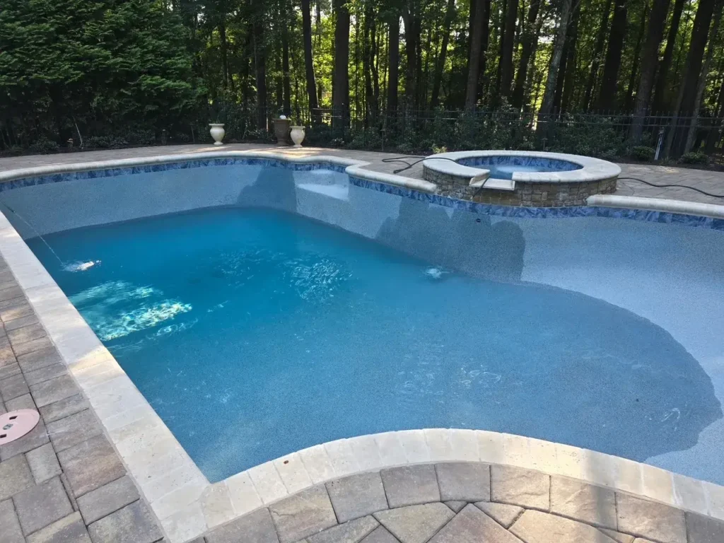 Renovated pool showing new waterline tile, coping and refreshed paver deck